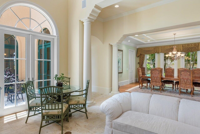 dining area with crown molding, a notable chandelier, and ornate columns