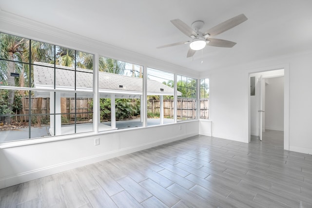 unfurnished sunroom featuring ceiling fan