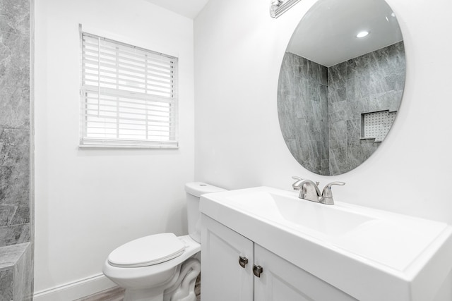 bathroom featuring hardwood / wood-style floors, vanity, toilet, and walk in shower