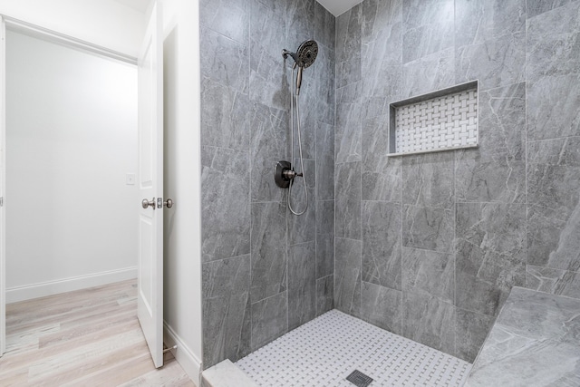 bathroom with hardwood / wood-style floors and tiled shower