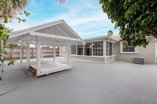 view of patio with central AC unit and a sunroom