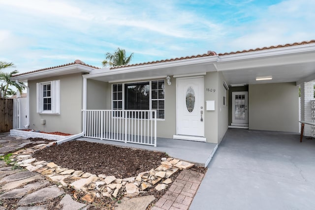 1609 N J Ter, Lake Worth, FL 33460 - view of front facade with stucco siding, a tiled roof, and covered porch