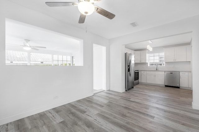 kitchen featuring sink, ceiling fan, light hardwood / wood-style floors, white cabinetry, and stainless steel appliances