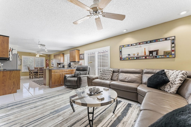 living room with light tile patterned floors, a textured ceiling, and ceiling fan