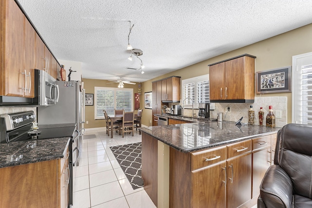 kitchen featuring kitchen peninsula, appliances with stainless steel finishes, ceiling fan, sink, and light tile patterned flooring