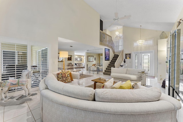 living room featuring light tile patterned flooring, ceiling fan with notable chandelier, and high vaulted ceiling