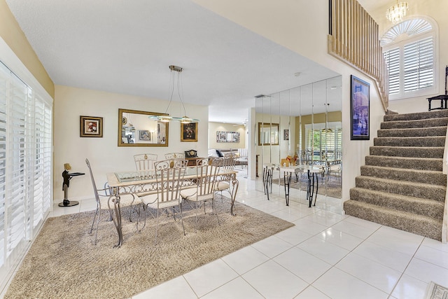 dining space with light tile patterned floors and a notable chandelier