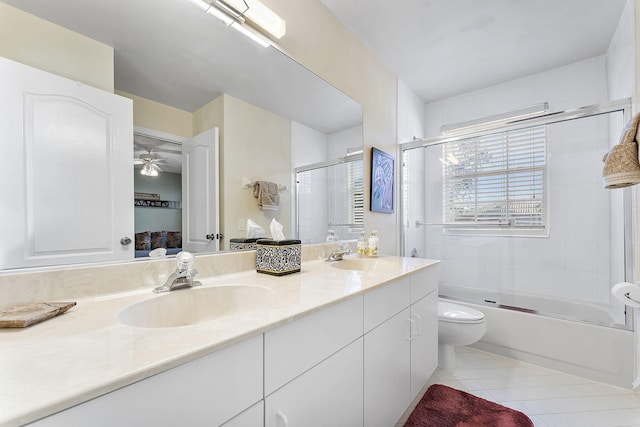 full bathroom with tile patterned floors, vanity, ceiling fan, enclosed tub / shower combo, and toilet