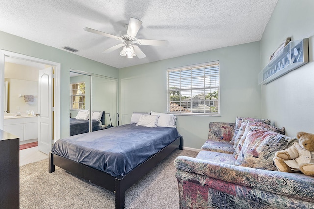 bedroom featuring light carpet, a textured ceiling, a closet, and ceiling fan