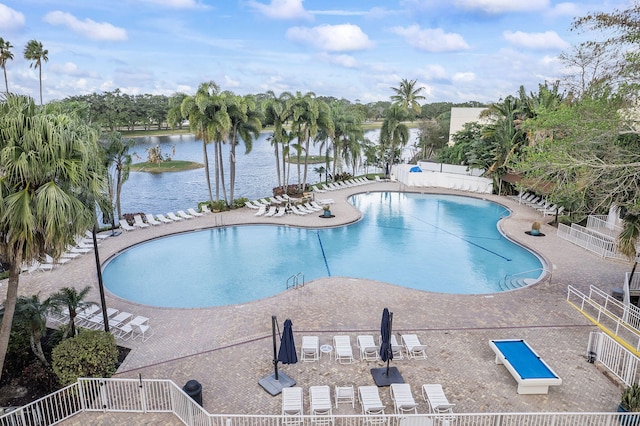 view of swimming pool with a water view and a patio