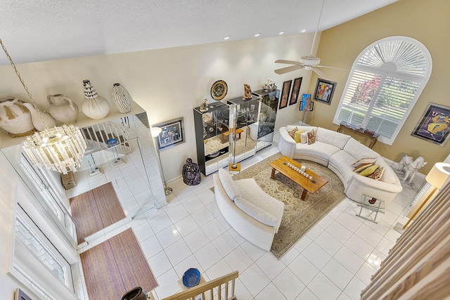 tiled living room featuring a textured ceiling, ceiling fan with notable chandelier, and high vaulted ceiling