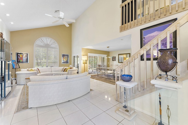 tiled living room featuring ceiling fan and high vaulted ceiling