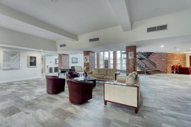 living room featuring beamed ceiling, a towering ceiling, and decorative columns