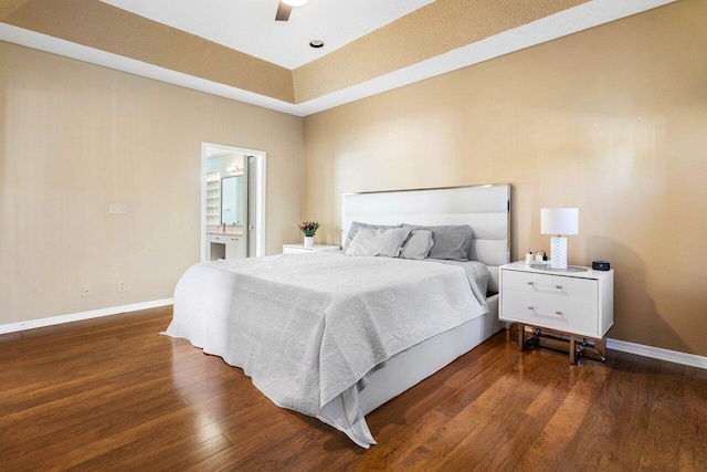 bedroom with ensuite bath, ceiling fan, and dark wood-type flooring