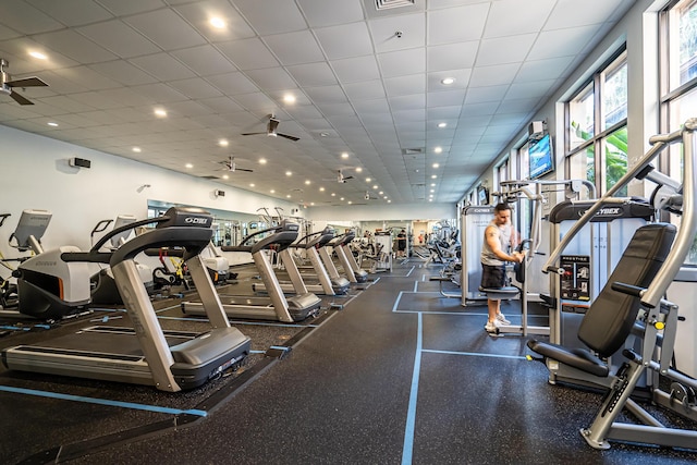 workout area featuring ceiling fan and a drop ceiling