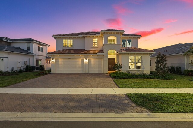 mediterranean / spanish home with a garage and a front lawn