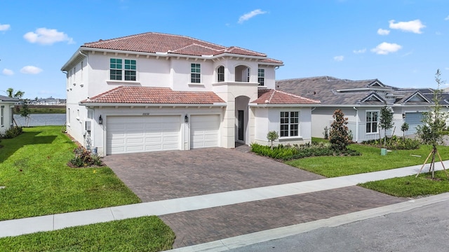 mediterranean / spanish house featuring a front yard and a garage