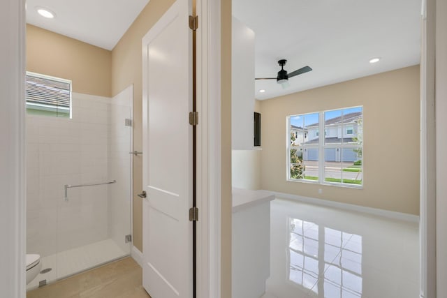 bathroom with ceiling fan, tile patterned flooring, a shower with shower door, and toilet