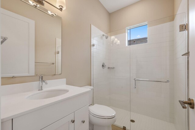 bathroom with walk in shower, vanity, and toilet