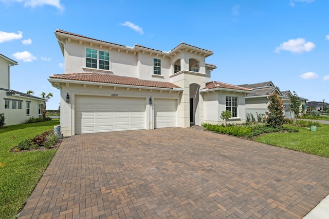 mediterranean / spanish-style home featuring a front yard and a garage