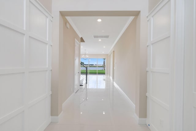 hall featuring light tile patterned floors and ornamental molding