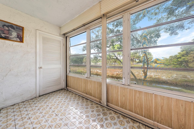 unfurnished sunroom featuring a water view