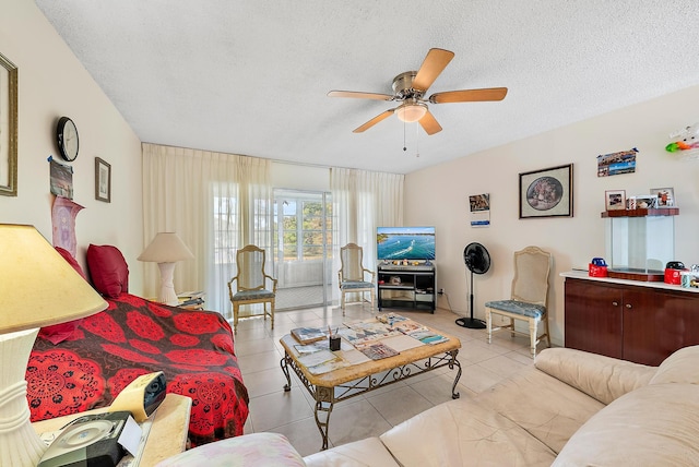 living room featuring ceiling fan, light tile patterned flooring, and a textured ceiling