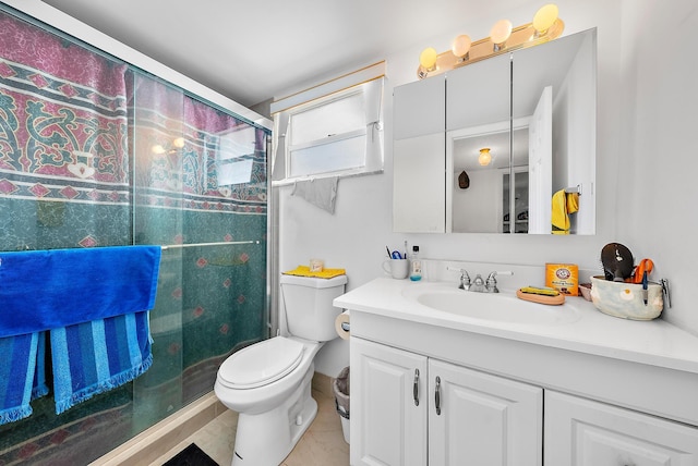 bathroom with tile patterned flooring, vanity, toilet, and a shower with shower door