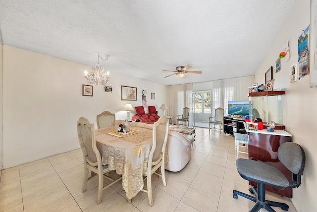 tiled dining room featuring ceiling fan with notable chandelier and a textured ceiling