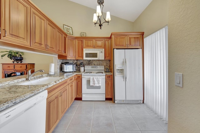 kitchen featuring white appliances, a notable chandelier, hanging light fixtures, lofted ceiling, and light tile patterned flooring