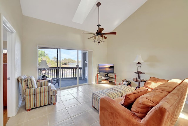 tiled living room featuring vaulted ceiling with skylight and ceiling fan