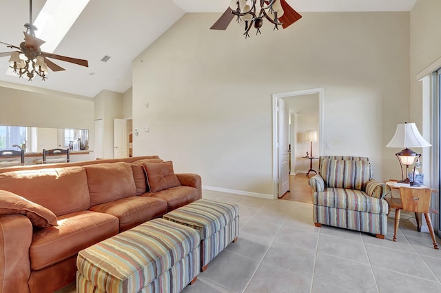 living room featuring ceiling fan, light tile patterned flooring, high vaulted ceiling, and a skylight