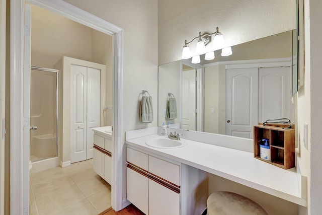 bathroom with tile patterned floors, vanity, and a shower with door