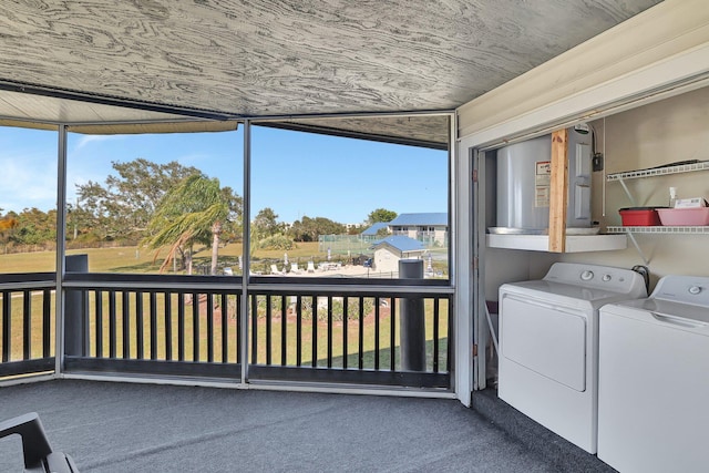 unfurnished sunroom featuring washing machine and clothes dryer, wooden ceiling, and a healthy amount of sunlight