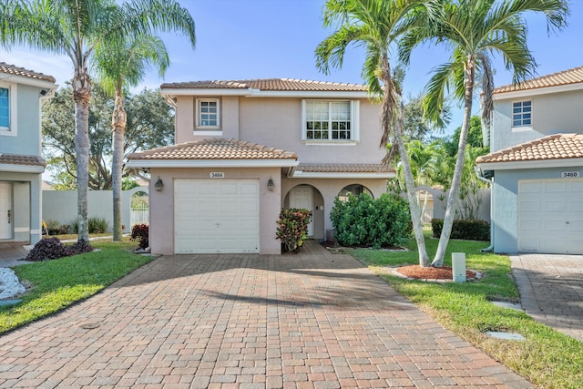 mediterranean / spanish-style home featuring a front yard and a garage