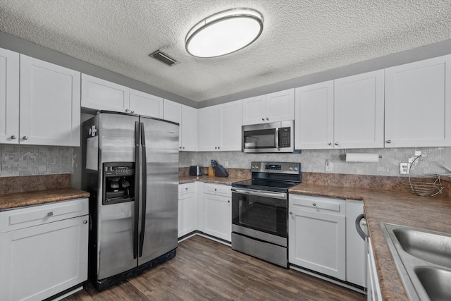 kitchen featuring appliances with stainless steel finishes, white cabinetry, and dark wood-type flooring