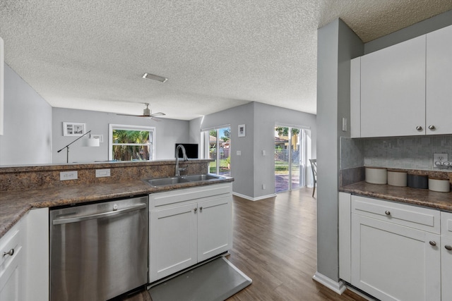 kitchen featuring white cabinetry, dishwasher, sink, dark hardwood / wood-style flooring, and a textured ceiling