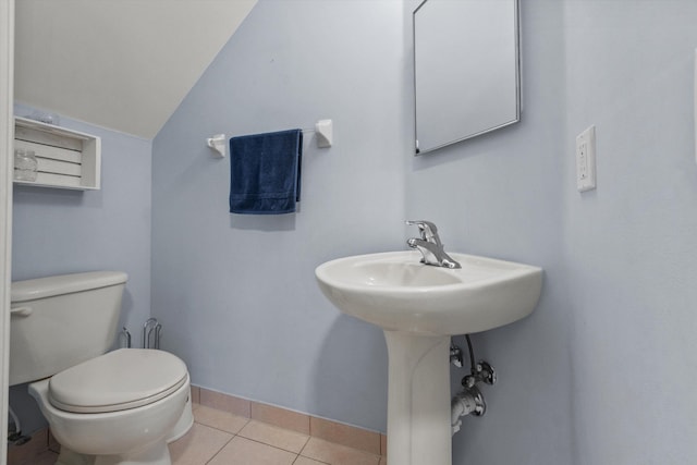 bathroom with toilet, vaulted ceiling, and tile patterned floors