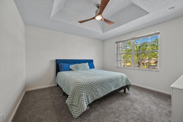 carpeted bedroom featuring ceiling fan and a textured ceiling