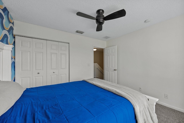 carpeted bedroom featuring a textured ceiling, a closet, and ceiling fan