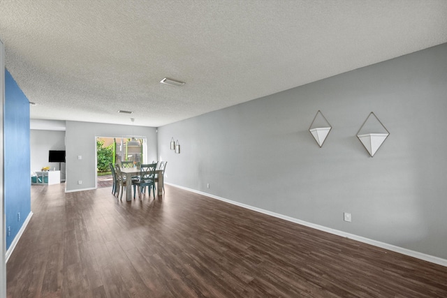 unfurnished dining area with a textured ceiling and dark hardwood / wood-style floors