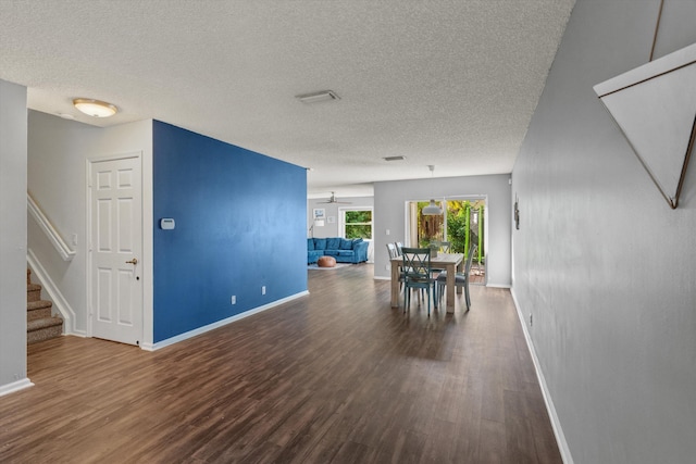 unfurnished dining area with hardwood / wood-style floors, ceiling fan, and a textured ceiling