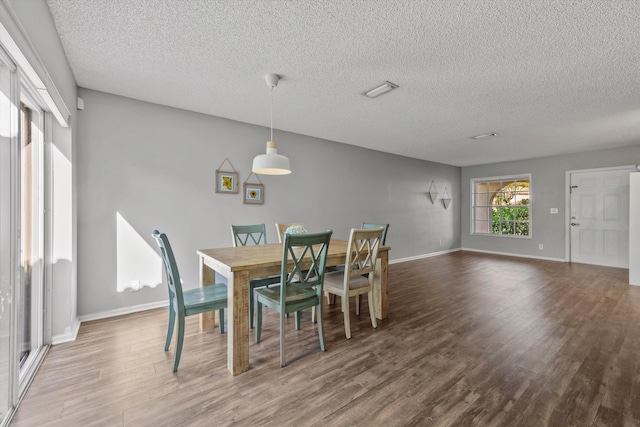 dining space featuring hardwood / wood-style floors and a textured ceiling