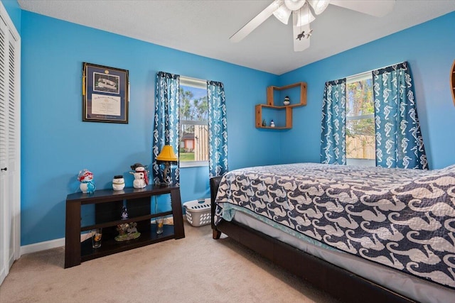 carpeted bedroom featuring ceiling fan and a closet