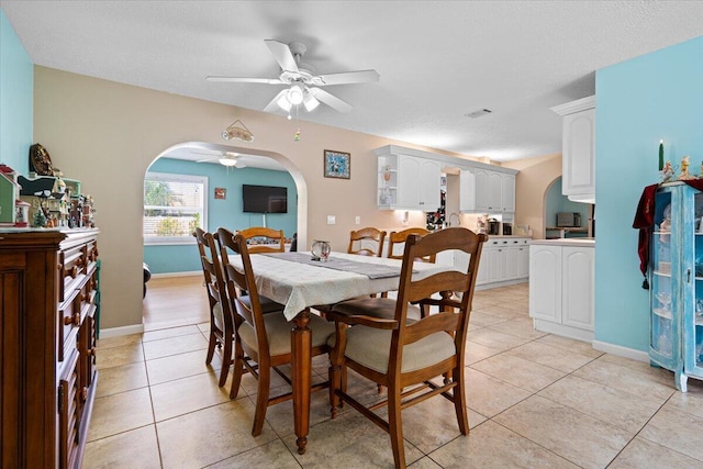 tiled dining space with ceiling fan