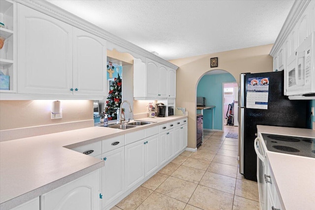 kitchen featuring sink, white cabinets, a textured ceiling, and white appliances