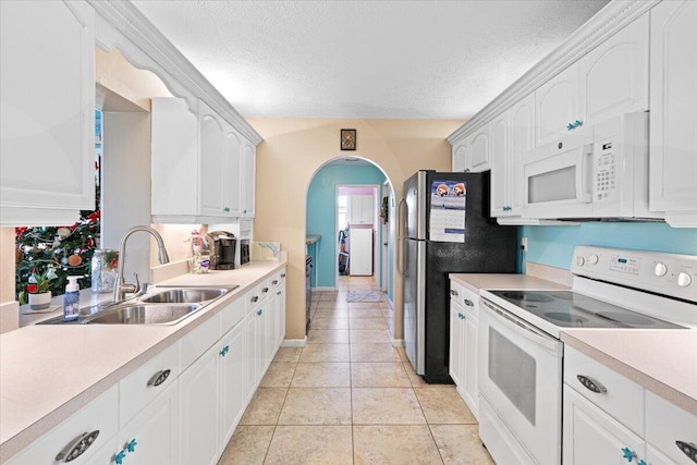 kitchen with white appliances, white cabinets, and sink