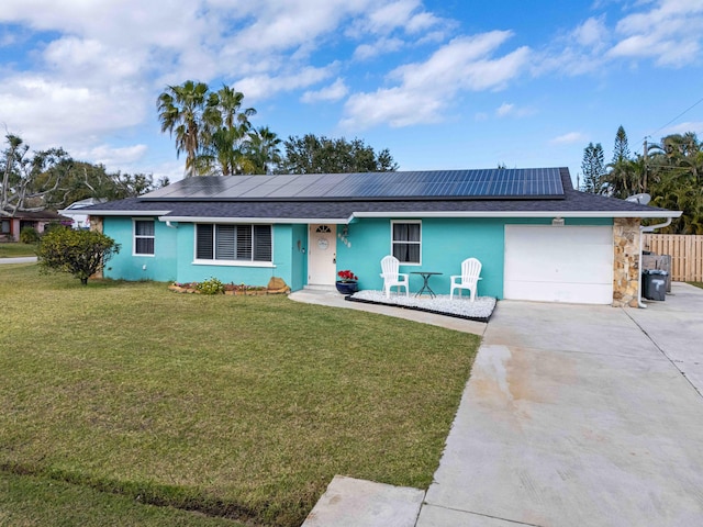 ranch-style house with a front lawn, solar panels, and a garage