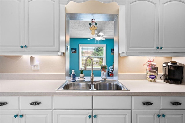 kitchen featuring sink, white cabinetry, ceiling fan, and a textured ceiling