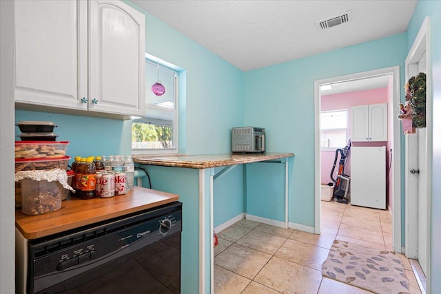 laundry room with a textured ceiling and light tile patterned flooring